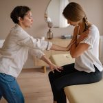 A Patient Sitting on the Therapy Bed in Front of a Therapist